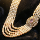 Social_Media_Video_Ads_A_layered_pearl_necklace_with_a_prominent_pink_kKzNF47E